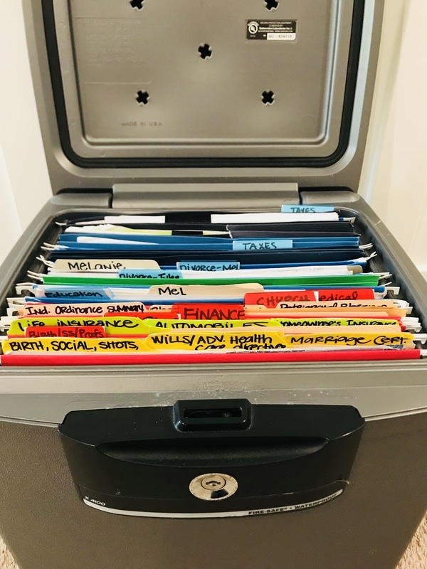 open fireproof waterproof safe full of file folders showing how Melanie is storing important documents.