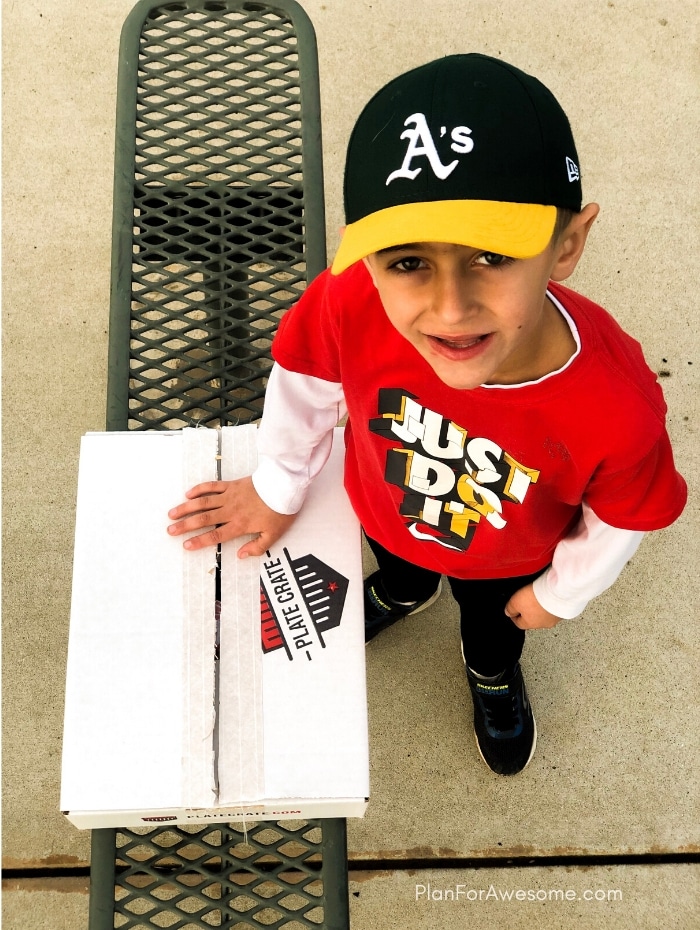 Happy little boy with his baseball subscription box!  The BEST GIFT EVER for Baseball Lovers (plus a $20 off coupon) - seriously the coolest and the easiest gift idea for baseball lovers and players!  A surprise box full of baseball gear, apparel, training aids, accessories, and snacks - what's not to love?!  #baseballgiftideas #baseballmom