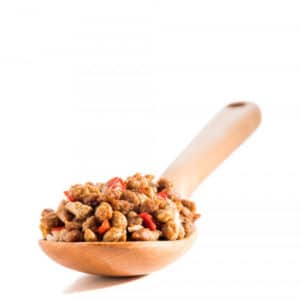 Thrive Life sausage crumbles sitting in a wood spoon.