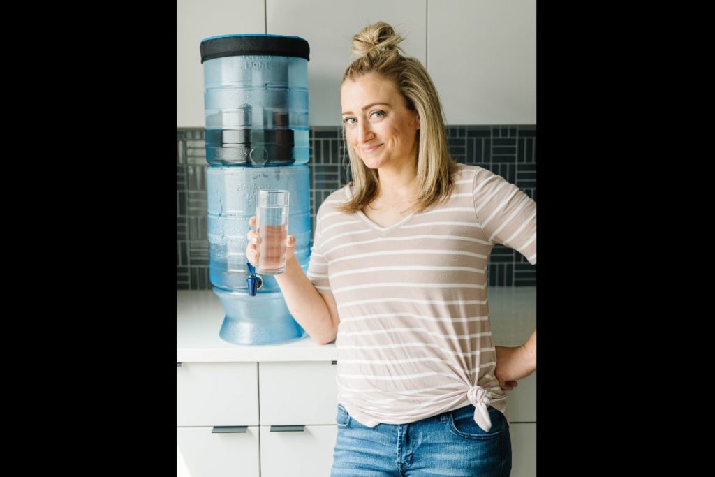 Melanie Papworth smiling next to a Berkey water filter