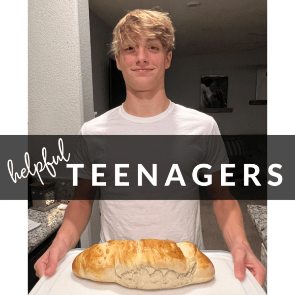 A teenage boy holding a load of homemade french bread that he made for 60 minutes of ride time.