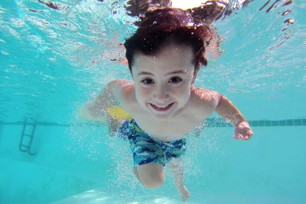toddler swimming under water smiling