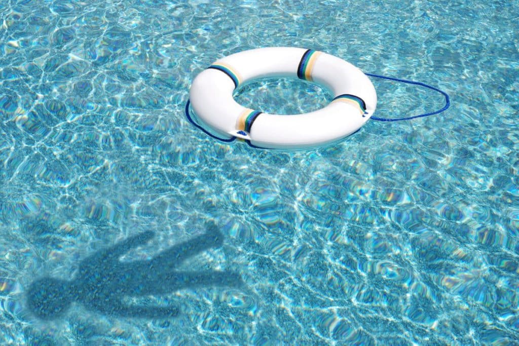 water in a blue swimming pool with white flotation device and shadow of child