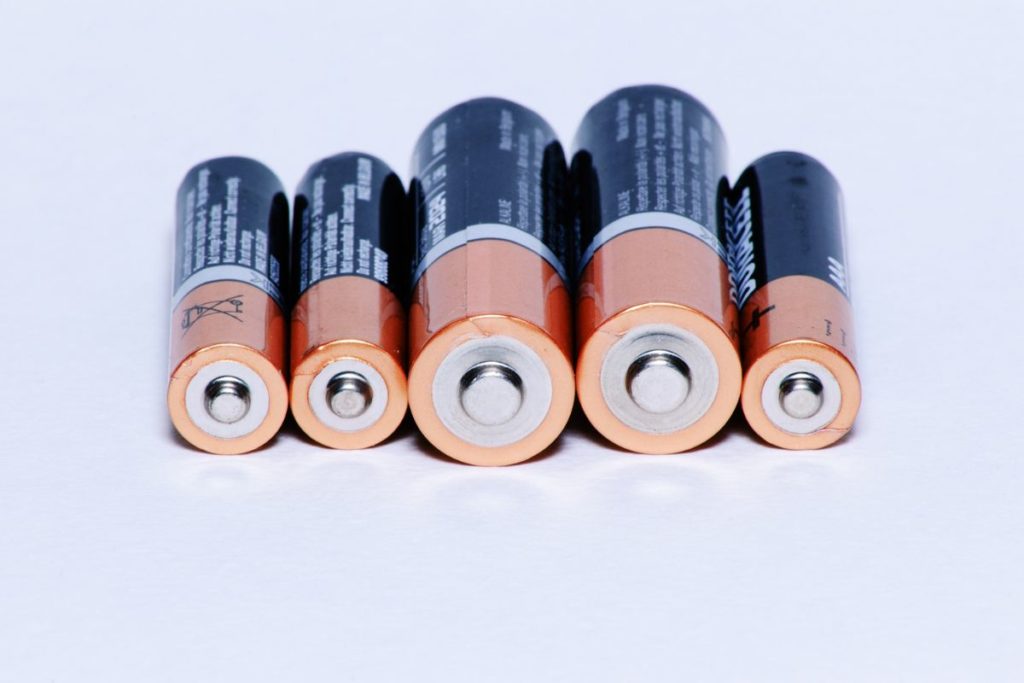 row of batteries on a white surface