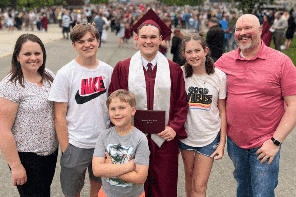 family of 5 with one teen wearing graduation cap and gown