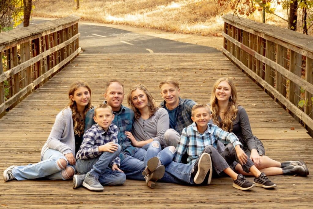 papworth family sitting on a bridge smiling