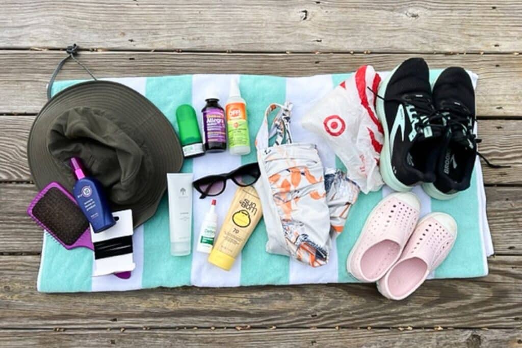 summer car kit items spread out on a beach towel.