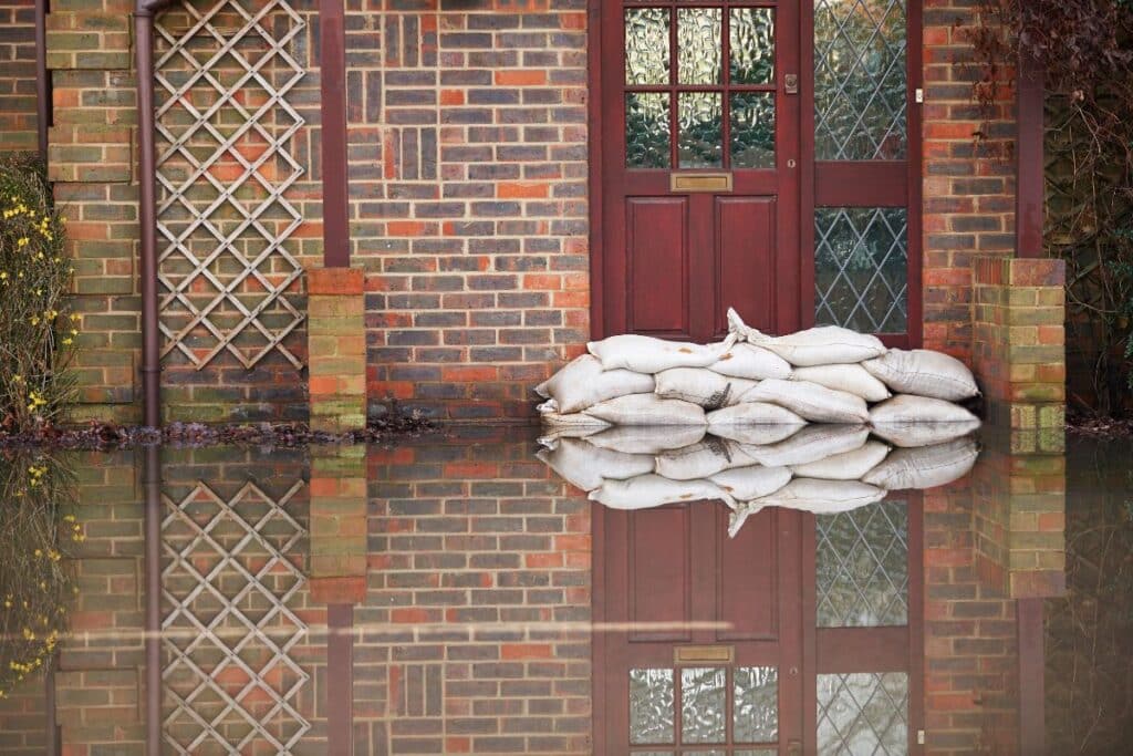 sandbags in front of front door of house to prepare for a flood.