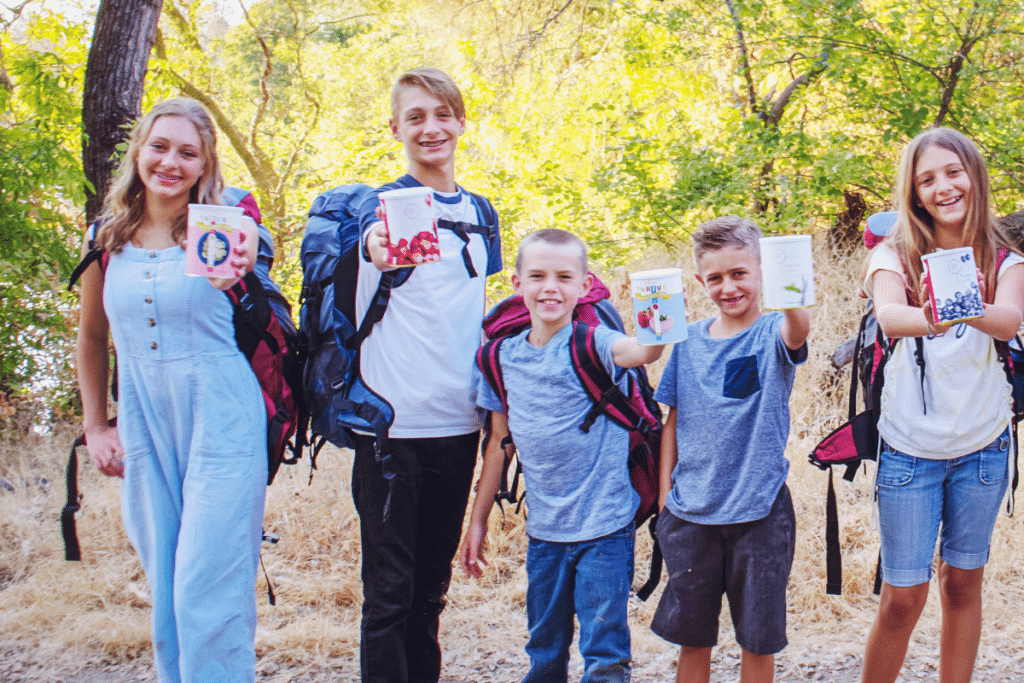 5 kids on a trail with 72 hour kits and cans of thrive life freeze dried foods.