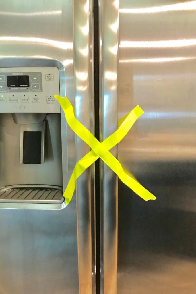 X of masking tape on refrigerator handles during a power outage.