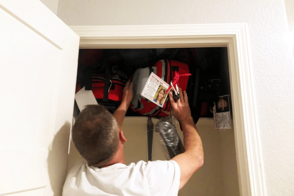 husband putting away emergency kit in closet.