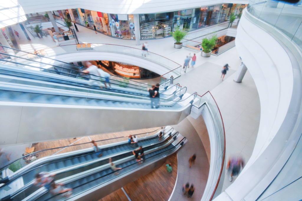 people walking around a mall and riding escalators.