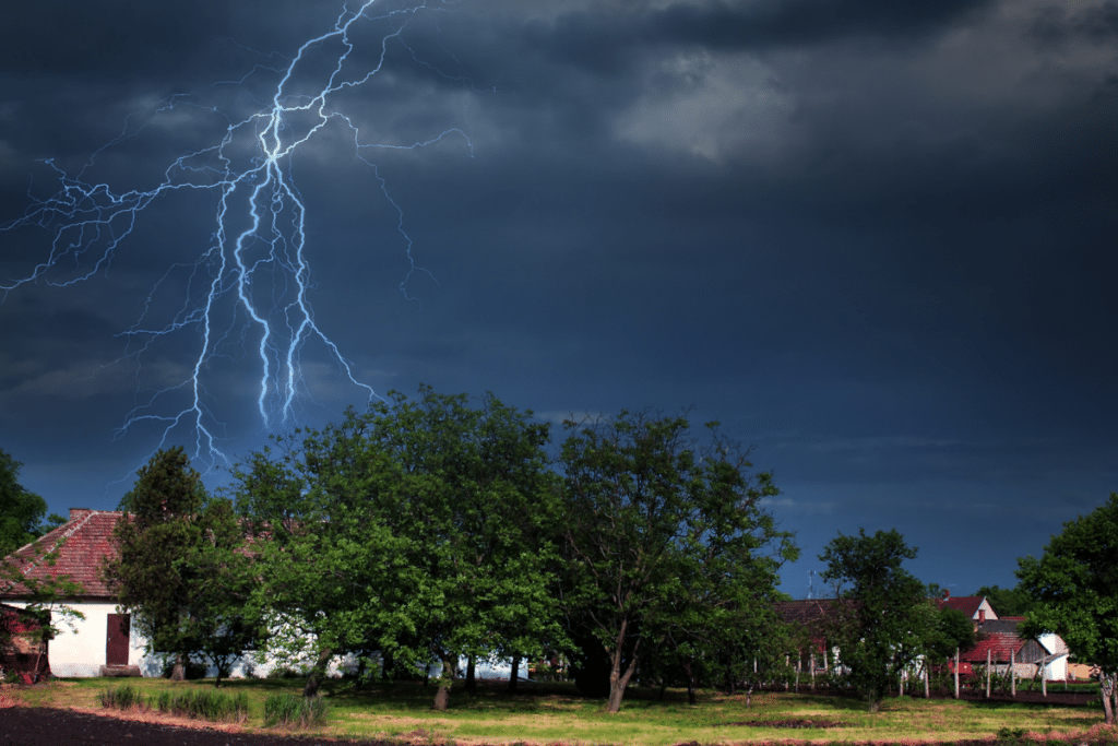 house surrounded by stormy clouds and lightning strikes.