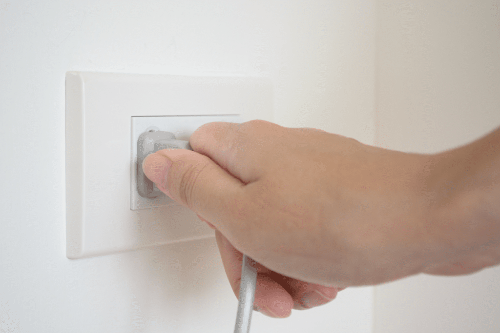 Man pulling a cord out of the wall.