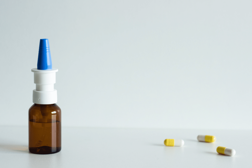 bottle of nasal spray and prescription capsules.