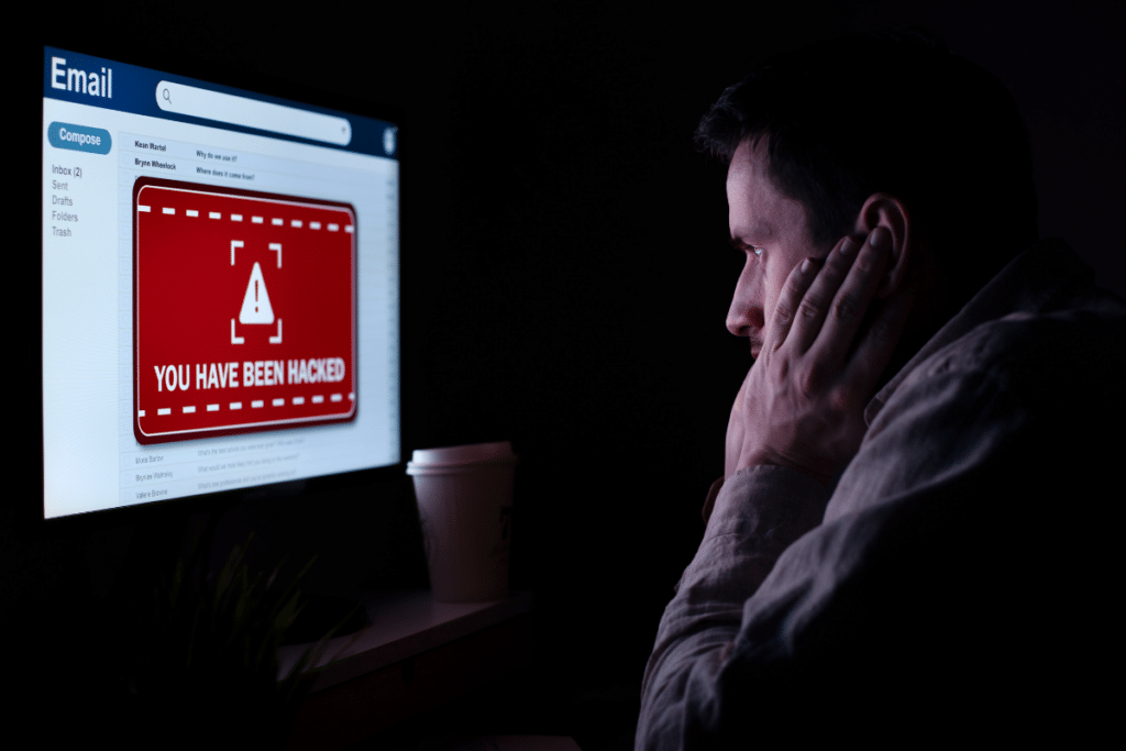 man staring at a computer that's been hacked.